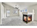 Bright living room with plush carpet, modern fireplace, and ample natural light at 6295 Clayton Cir, Frederick, CO 80530