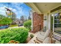 Charming front porch with cozy seating, decorative plants and brick accents enhancing curb appeal at 1011 S Valentia St # 30, Denver, CO 80247