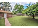 Grassy backyard featuring a shed, mature trees, and privacy fencing at 2526 W 39Th Ave, Denver, CO 80211