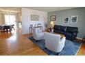 Cozy living room with hardwood floors, blue rug, blue couch, and modern furnishings at 308 Baron Ave, Lafayette, CO 80026