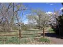 Picturesque dirt path lined by a weathered split rail fence and lush trees at 308 Baron Ave, Lafayette, CO 80026