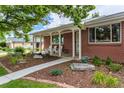 Front porch of brick ranch home with landscaping and walkway at 476 S Newport Way, Denver, CO 80224