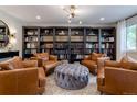 Living room with leather armchairs, ottoman, and built-in bookcase at 476 S Newport Way, Denver, CO 80224