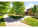 Scenic view of a two-story home surrounded by lush greenery and a concrete walkway at 8571 Gold Peak Dr # F, Highlands Ranch, CO 80130