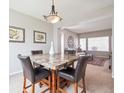 Dining area featuring a marble table with four chairs, and an open view into the bright living room at 8766 Cresthill Ln, Highlands Ranch, CO 80130