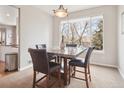Cozy dining area with a marble table, four chairs, and natural light from a large window at 8766 Cresthill Ln, Highlands Ranch, CO 80130