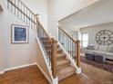 Elegant entryway with hardwood floors, a staircase with wooden rails, and views into a living room at 8766 Cresthill Ln, Highlands Ranch, CO 80130