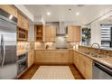 Stainless steel appliances and light wood cabinets in a modern kitchen at 1800 Lawrence St # 505, Denver, CO 80202