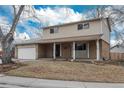 Traditional home featuring brick and vinyl siding, covered entry and attached garage at 13778 W 71St Pl, Arvada, CO 80004