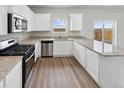 Modern kitchen with granite countertops, stainless steel appliances, and wood-style flooring at 2154 Alyssa St, Fort Lupton, CO 80621