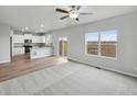 Open-concept living area featuring plush carpeting, natural light, and a view into the kitchen at 2154 Alyssa St, Fort Lupton, CO 80621