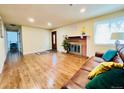 Bright living room with hardwood flooring, fireplace, and large window at 2543 Westchester Dr, Denver, CO 80221