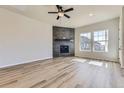 Open-concept living room with a fireplace, large windows, and hardwood floors at 8946 S Rome Ct, Aurora, CO 80016