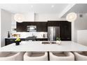 Bright kitchen featuring a large island with seating, modern appliances, and elegant sphere pendant lighting at 4395 Zuni St, Denver, CO 80211