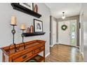 Inviting entryway with hardwood floors, decorative shelving, and a white front door with a wreath at 5656 S Sicily Ct, Aurora, CO 80015