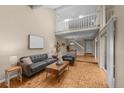 Spacious living room with parquet floors and an open floor plan leading to a dining area and staircase at 11704 Elk Head Range Rd, Littleton, CO 80127