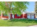 Traditional home showcasing a lush front lawn, mature trees, and well-maintained landscaping at 5332 W Roxbury Pl, Littleton, CO 80128