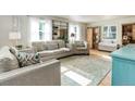 Bright living room features hardwood floors, neutral-toned furnishings, and ample natural light at 5332 W Roxbury Pl, Littleton, CO 80128