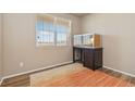 Cozy bedroom with hardwood floors, a large window, and a built in desk with drawers at 567 Jewel St, Brighton, CO 80603