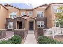Inviting townhome exterior with brick accents and lovely landscaping around a sidewalk entrance at 15443 W 65Th Ave # B, Arvada, CO 80007