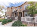 Lovely exterior view of a tan-colored townhome with brick accents and well-maintained landscaping at 15443 W 65Th Ave # B, Arvada, CO 80007