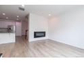 Contemporary living room with sleek electric fireplace and modern, light wood-look floors at 15443 W 65Th Ave # B, Arvada, CO 80007