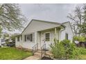 Inviting one-story home with a well-maintained lawn and white siding complemented by dark green trim at 5370 S Sherman St, Littleton, CO 80121