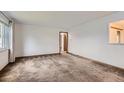 Bright living room featuring neutral carpet, white walls, and a large window for plenty of natural light at 5370 S Sherman St, Littleton, CO 80121