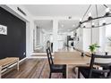 Bright dining room with a modern chandelier, and views of the updated kitchen and staircase at 20765 E 39Th Ave, Denver, CO 80249