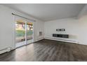 Bright living room features wood floors, fresh white paint, and sliding glass door at 4569 S Lowell Blvd # B, Denver, CO 80236