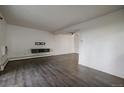 Bright living room features wood floors, fresh white paint, and a floating shelf at 4569 S Lowell Blvd # B, Denver, CO 80236