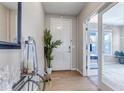 Inviting foyer with hardwood floors, a glass table, a mirror, and a decorative plant, bathed in soft natural light at 9592 Keystone Trl, Parker, CO 80134