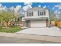 Charming two-story home with brick accents, a spacious driveway, and a well-manicured lawn at 4924 S Flower Way, Littleton, CO 80123