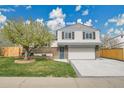 Charming two-story home with brick accents, a spacious driveway, and a well-manicured lawn at 4924 S Flower Way, Littleton, CO 80123