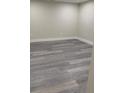 Clean, bright basement area with modern gray vinyl flooring and fresh paint at 1125 S Eaton Ct, Lakewood, CO 80232