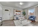 Bright living room with stylish flooring, a comfy sofa, and lots of natural light from the large window at 3090 W Longfellow Pl, Denver, CO 80221