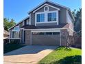 Inviting two-story home featuring a well-manicured lawn, attached garage, and beautiful curb appeal at 9668 Salem Ct, Highlands Ranch, CO 80130