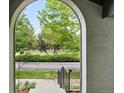 Front yard view framed by a stone archway from the front porch of the home at 8276 E 28Th Dr, Denver, CO 80238