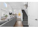 Bright, open-concept living room features high ceilings, modern decor, and staircase at 10101 E 112Th Way, Commerce City, CO 80640