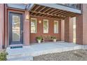 Inviting front porch with a bench, planters, and a covered area with exposed beam rafters at 3795 Depew St # D, Wheat Ridge, CO 80212
