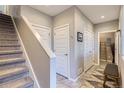 Hallway with gray walls, white trim, and a staircase leading to the upper level with a tiled floor at 3795 Depew St # D, Wheat Ridge, CO 80212