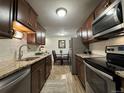 Modern kitchen with stainless steel appliances, granite countertops, and a view to the dining area at 2325 S Linden Ct # 211, Denver, CO 80222