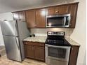 Cozy kitchen with stainless steel appliances and brown cabinets at 2325 S Linden Ct # 211, Denver, CO 80222