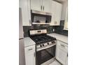 Close-up of stainless steel oven, microwave, white cabinets and sleek countertops at 1273 Newark St, Aurora, CO 80010