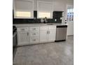 Updated kitchen features modern white cabinetry, stainless steel appliances and tile flooring at 1273 Newark St, Aurora, CO 80010