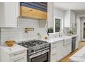 Modern kitchen with white cabinets, marble counters, and gold accents at 5576 E Lehigh Ave, Denver, CO 80237