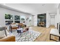 Inviting living room showcases hardwood floors, a fireplace, and large windows offering plenty of natural light at 5576 E Lehigh Ave, Denver, CO 80237