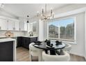 Bright dining area features a modern chandelier and a large window overlooking the neighborhood at 5068 E Crestone Ave, Castle Rock, CO 80104