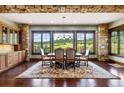 Elegant dining room featuring stone walls, wood floors, and scenic mountain views at 2480 Castle Butte Dr, Castle Rock, CO 80109