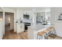 Bright, renovated kitchen with white cabinets, stainless steel appliances, and marble countertops at 3780 Benton St, Wheat Ridge, CO 80212
